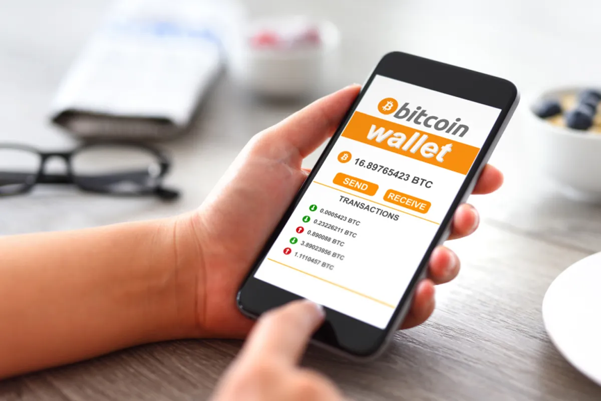 فردی از طریق موبایل اش در حال خرید و فروش بیت کوین است.